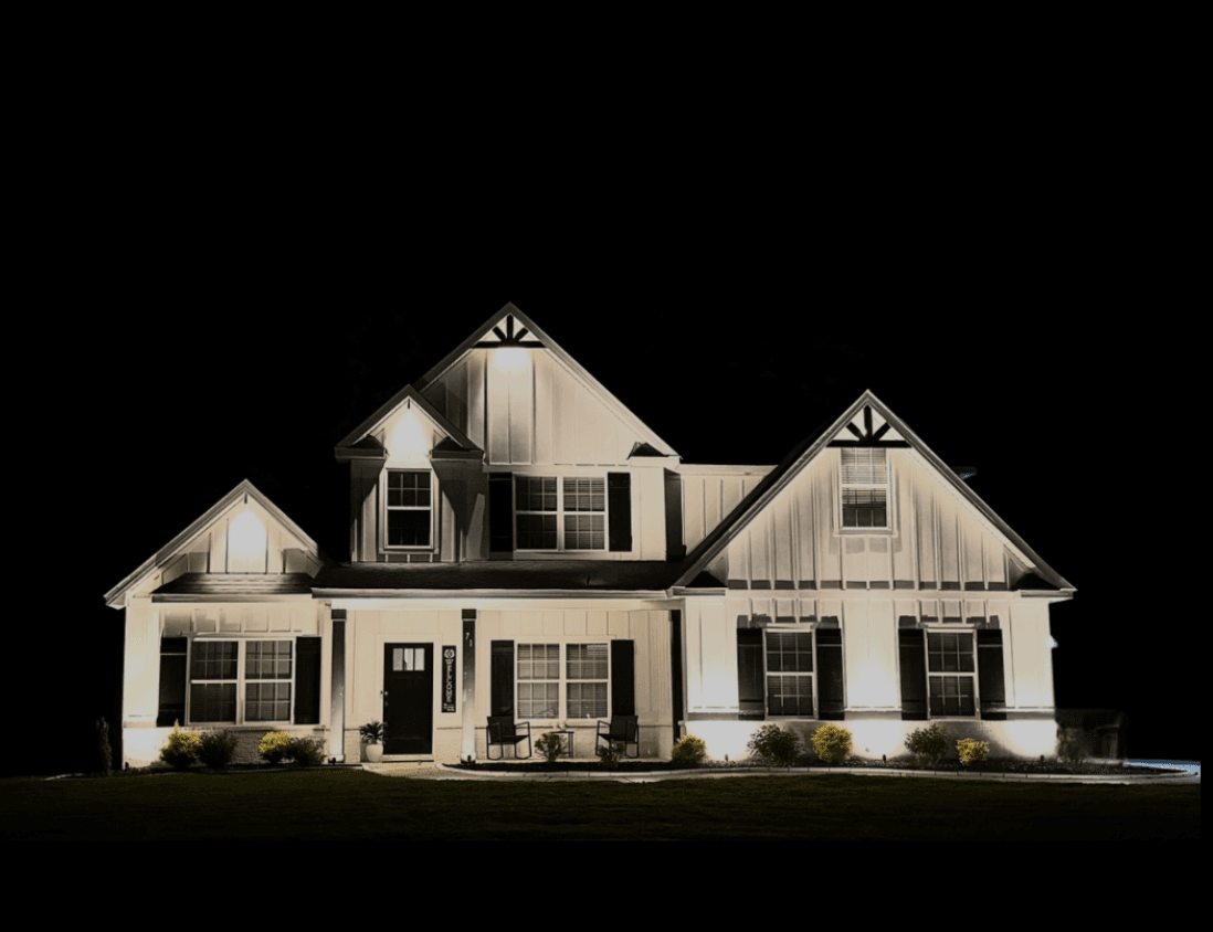 Large white farmhouse with comprehensive uplighting