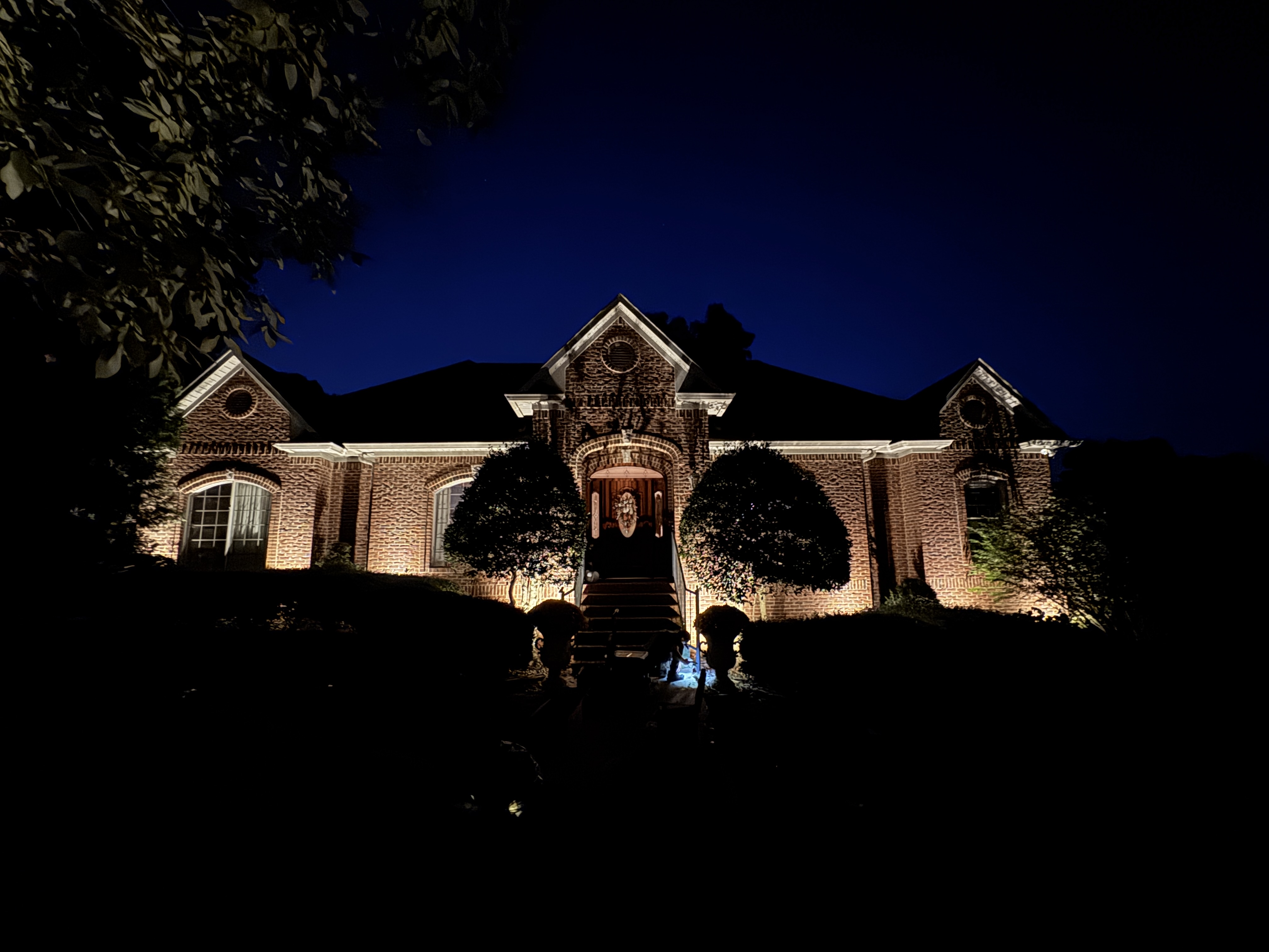 Professional exterior lighting installation showcasing luxury home