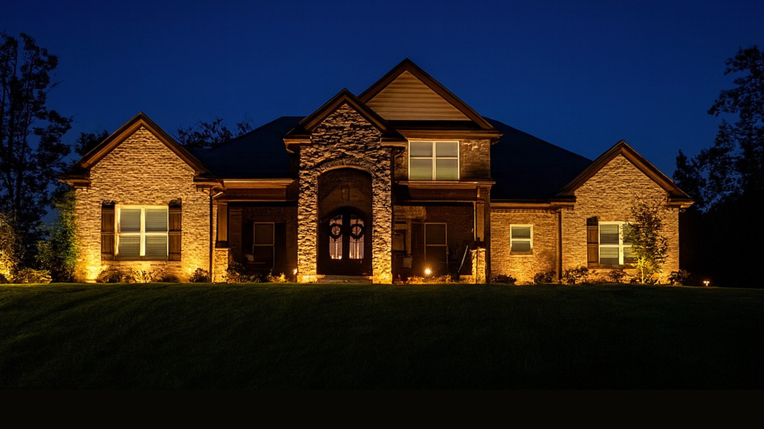 Luxury Brick Home Architectural Lighting Luxury brick home with warm architectural uplighting