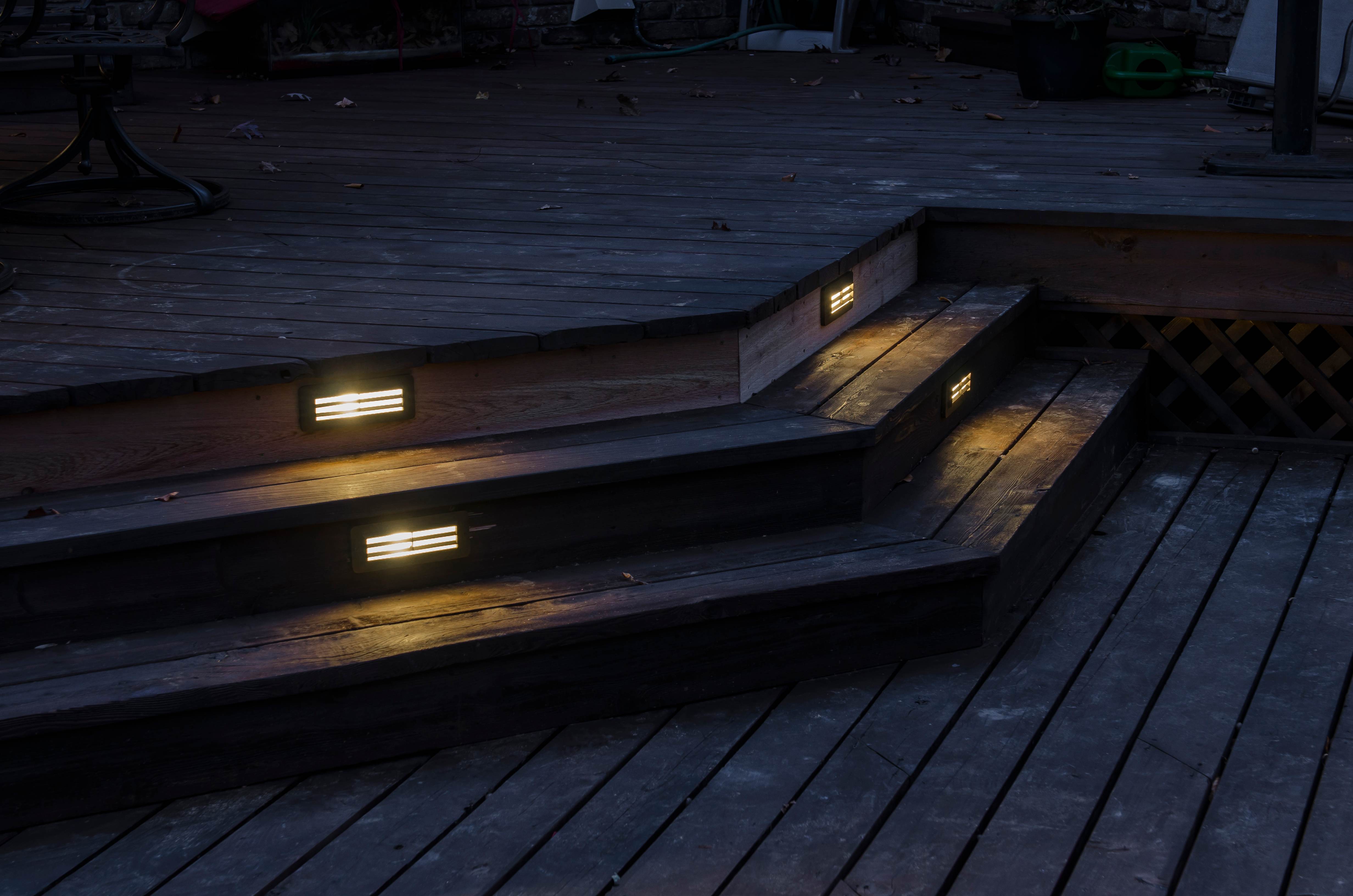Deck Step Lighting Installation Deck step lighting at night showing recessed lights in wooden deck stairs for safety and ambiance