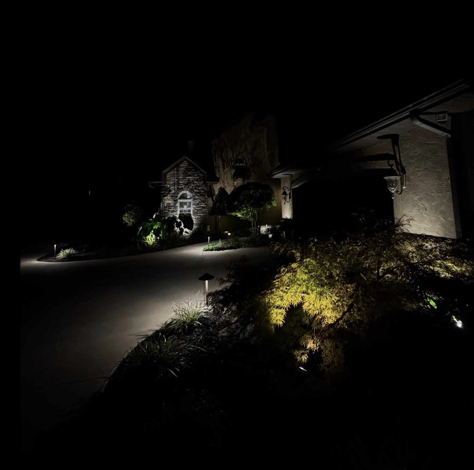Driveway Approach Lighting Stone home with dramatic driveway approach lighting
